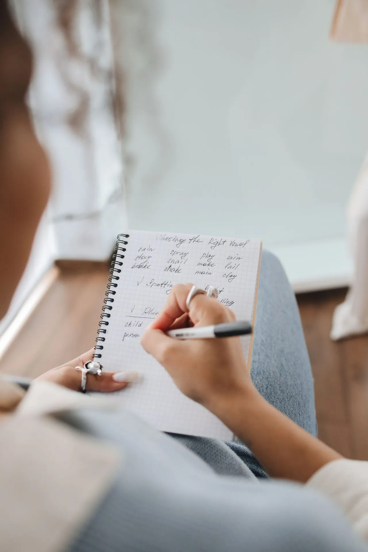Student writing notes in a notebook while studying Russian grammar